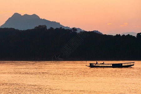 运输在老挝LuangPrabang黄昏的湄公河上一艘当地渡船屋顶上放松旅游者一种当地的图片