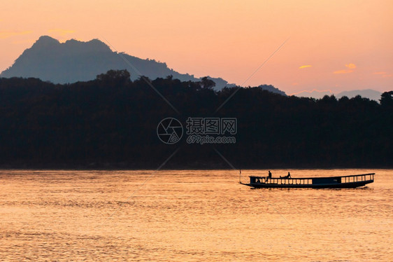 运输在老挝LuangPrabang黄昏的湄公河上一艘当地渡船屋顶上放松旅游者一种当地的图片