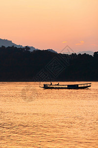 地平线旅行者亚洲在老挝LuangPrabang黄昏的湄公河上一艘当地渡船屋顶上放松旅游者图片