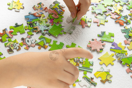 幼儿园知识孩子玩拼图的手玩彩色拼图通过玩具培养孩子儿童玩拼图孩子的手玩五颜六色拼图学习图片