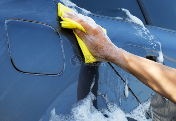 闪耀肮脏的用黄海绵洗灰色汽车女用肥皂泡沫洗手机用黄色海绵洗灰汽车雨刮器图片