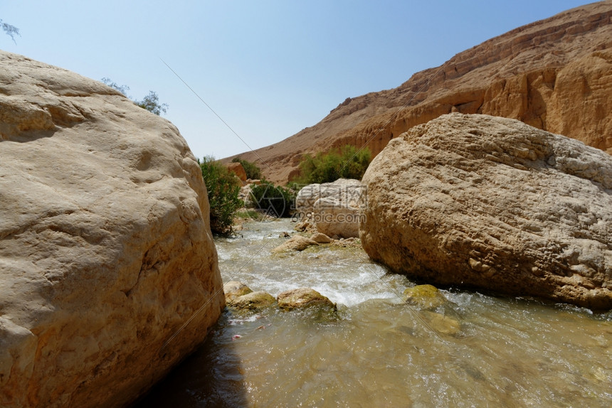 泡沫约旦沙漠中的WadibinHammad小溪流巨石图片