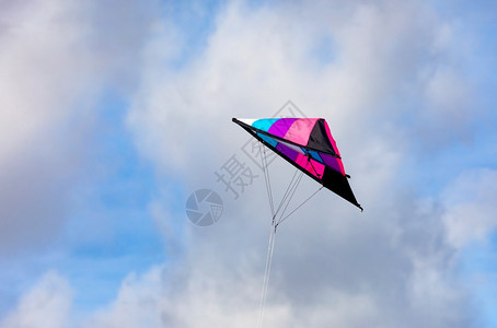 在蓝天空中飞来去的多彩风筝尾巴爱好有图片