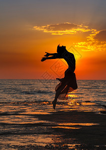 海边夕阳下跳舞的女性图片