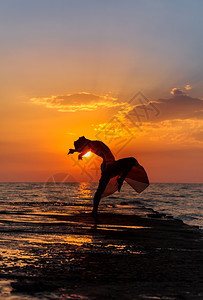 海边夕阳下跳舞的女性图片