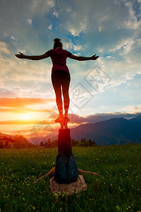 活力日落时山上自然的浪漫气氛中男Acroyoga女孩浪漫的闲暇图片