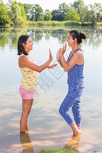 站立两位朋友在湖水中一起玩夏天印度人图片