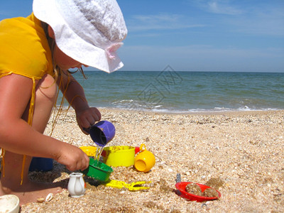 小女孩在海边沙滩上玩耍图片