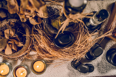 古装瓶和按摩巴萨勒特桌上的金宝石和蜡烛中的香油瓶子烛光玄武岩图片