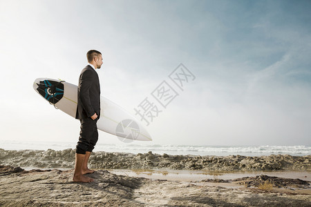 假期商人拿着冲浪板来到海边图片