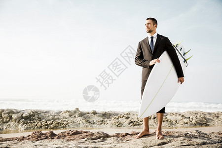 假期商人拿着冲浪板来到海边图片