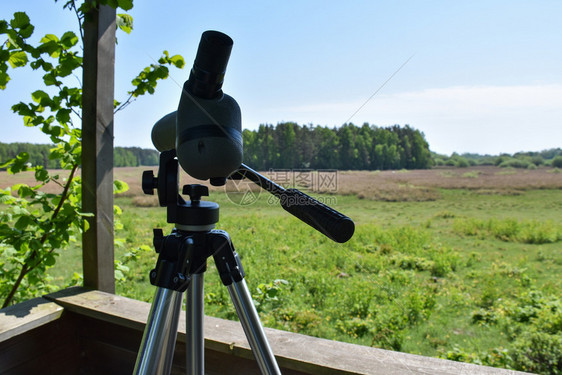 双目景观绿色在瑞典岛上的观鸟塔一只三脚架的望远镜从观鸟塔传来的察图片