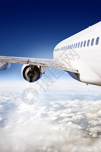 蓝色的旅行引擎从飞机后翼看到飞行中的商业客机在飞行中图片