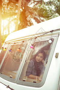 冒险车辆旅行夏日坐在野营车里的美丽年轻女士图片