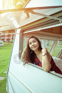 运输闲暇户外夏日坐在野营车里的美丽年轻女士图片