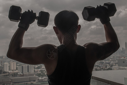 背部起重泰国曼谷2019年月6日男运动员在健身或俱乐部训练肌肉用举重的哑铃来训练肌肉男运动员用哑铃来训练肌肉的力量积极的图片