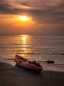 地平线天堂超过日出时亮海上有橙色的清晨天空泰国海滩上有皮艇图片