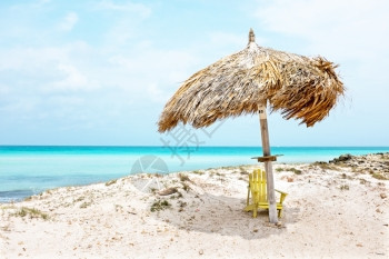 假期遮阳板暮加勒比阿鲁巴岛海滩上的草伞在加勒比阿鲁巴岛的海滩上图片