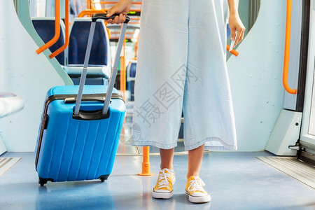贴近一个举着手提箱的无法辨认女人搭火车旅行高品质照片贴近一个拿着手提箱无法识别的女人乘火车旅行不能辨认高的面目全非套装图片