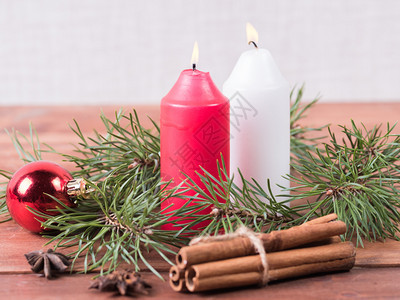 冷杉两根蜡烛在木背景上配有一根树枝和棵圣诞带红球新年背景两根蜡烛松树分支和圣诞节背景的舞会庆典领域图片