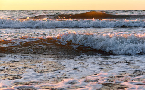 黎明红色的阳光下海浪上日落边出阳光下海浪边日出支撑图片