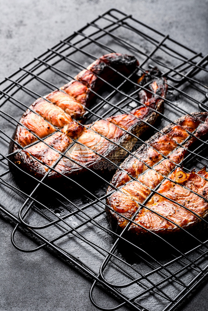 鱼片铁烤格网上的灰鲑鱼在暗底背景最深的视野下BBQ海产鲜条纹文本小吃食物图片