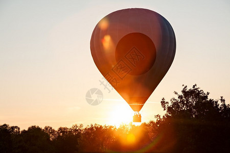充气的明亮飞艇在剪影热气球准备起飞反对太阳在剪影的热气球准备在飞行中起图片