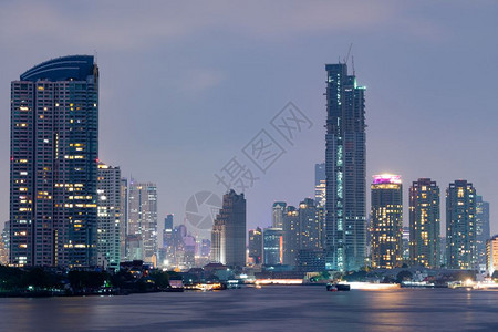 曼谷市建摩天大楼在夜间城市风景的光照下建造平坦的曼谷市酒店水天际线图片