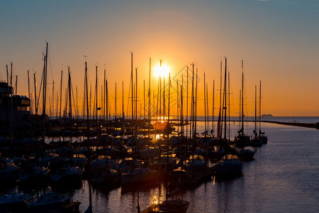 晚上码头的渔船排行数与日落和黄昏照明轮廓安宁天际线图片