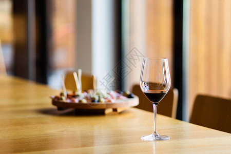 酒吧美食饮料家餐桌上的红酒杯子在窗边的模糊开胃菜前或者在餐厅前图片