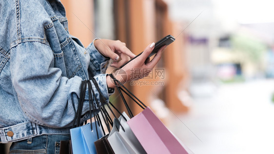 买钱在购物检查促销过程中使用移动电话的近身妇女手贴上人们图片
