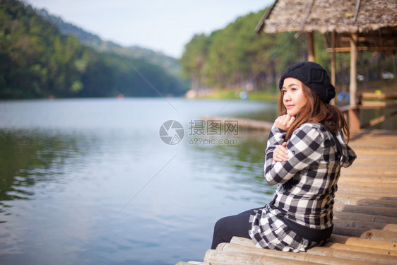 女士安静的坐在码头上女人看着日落的美丽水图片