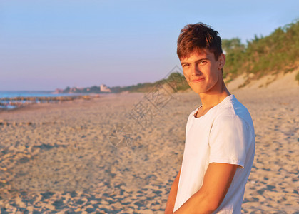 一个年轻人在沙滩上欣赏风景图片