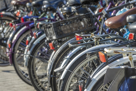 健康循环车轮荷兰阿姆斯特丹自行车泊日的荷兰阳光大量新旧自行车在阳光日骑着许多自行车的泊场图片