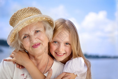 欢乐的外婆和孙女在日落阳光大约拥抱图片