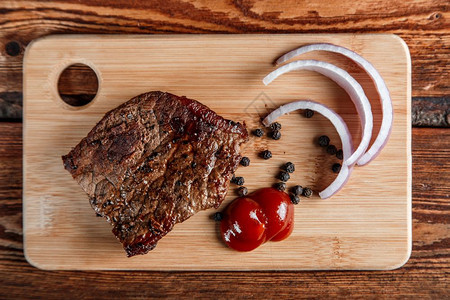 一种迷迭香牛腩用料和番茄酱在破旧的木质背景上烤肉图片