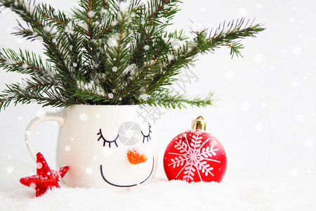 一个杯子中的雪花圆枝面顶着一个沉睡的雪人一个红圣诞舞会和一个白背景的星喜悦假期睡着了图片