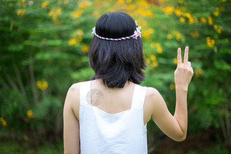 女孩有着和平迹象的美丽亚洲年轻女子花圈手指图片