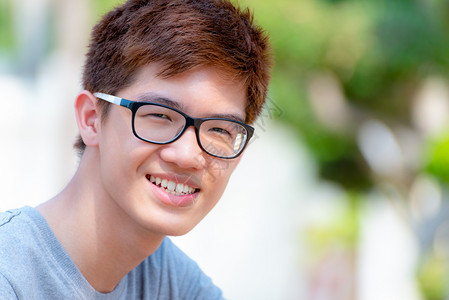 潮人亚洲穿着眼镜的亚洲英俊十几岁的男孩肖莱特快乐的时装男青年在
