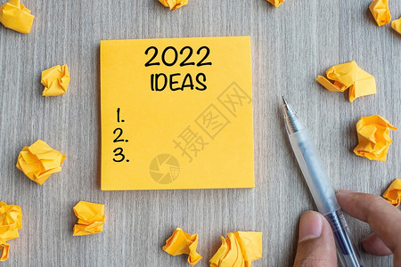 假期20年新开端决议战略任务概念等木制表格背景的纸笔和碎上写着新年开始任务概念的桌子图片