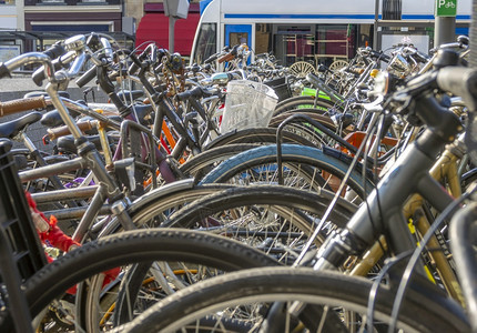 车辆在阿姆斯特丹的一条街上阳光明媚的一天骑自行车停泊在阿姆斯特丹的一条街道上许多自行车和电在背景中很多自行车和电在阿姆斯特丹的S图片