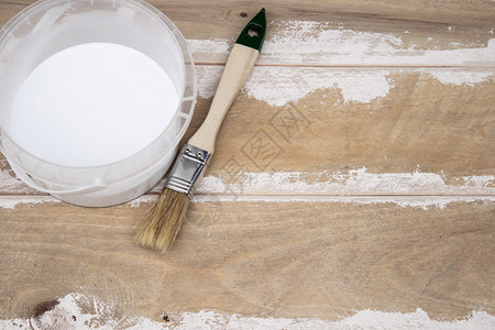工作具油漆刷和木板上有白色油漆的罐头板准备从上面看油漆刷和木板上有白色油漆的罐头为概念准备木质表面能够图片