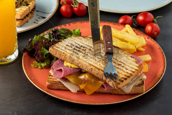 法语一顿饭Cheddar奶酪火腿和鸡蛋面包加橙汁和黑石桌上的薯条美味图片