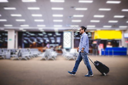 到达亚洲人旅行者在机场步和运输李箱的亚洲人旅行男们图片