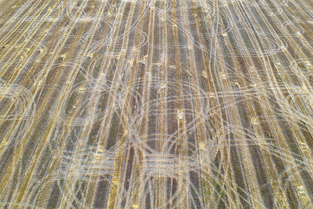 培养收割后有拖拉机痕迹的农田地自然背景以上干草抽象的图片