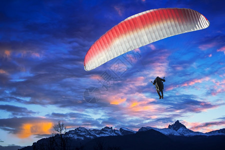 冬季日落时滑翔伞在山上飞过区冬天活动风险图片