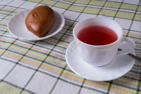 健康站在桌上的白杯喝着水果茶和一盘白杯馅饼子里有水果茶和蛋糕卡德有机的图片