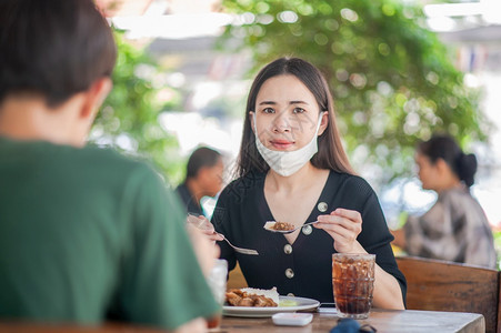 工作采用亚裔女使面罩坐在餐厅软焦点新正常概念的餐饮中服务图片