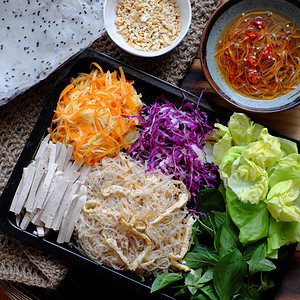 一种新鲜素食大米纸卷的顶端食品一个受欢迎的越南人吃着健康的食物吃着丰富多彩的蔬菜如胡萝卜紫菜卷心香肠维米切利豆腐沙拉草药等紫色高图片