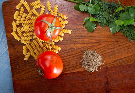 新鲜产品营养餐桌切菜板上配有烹饪意面的成分粉切割板上配有一个工件的面粉两个红西番茄和香料图片